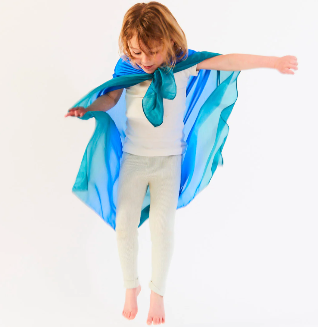 A child wears a playsilk as a cape The Doodle Post