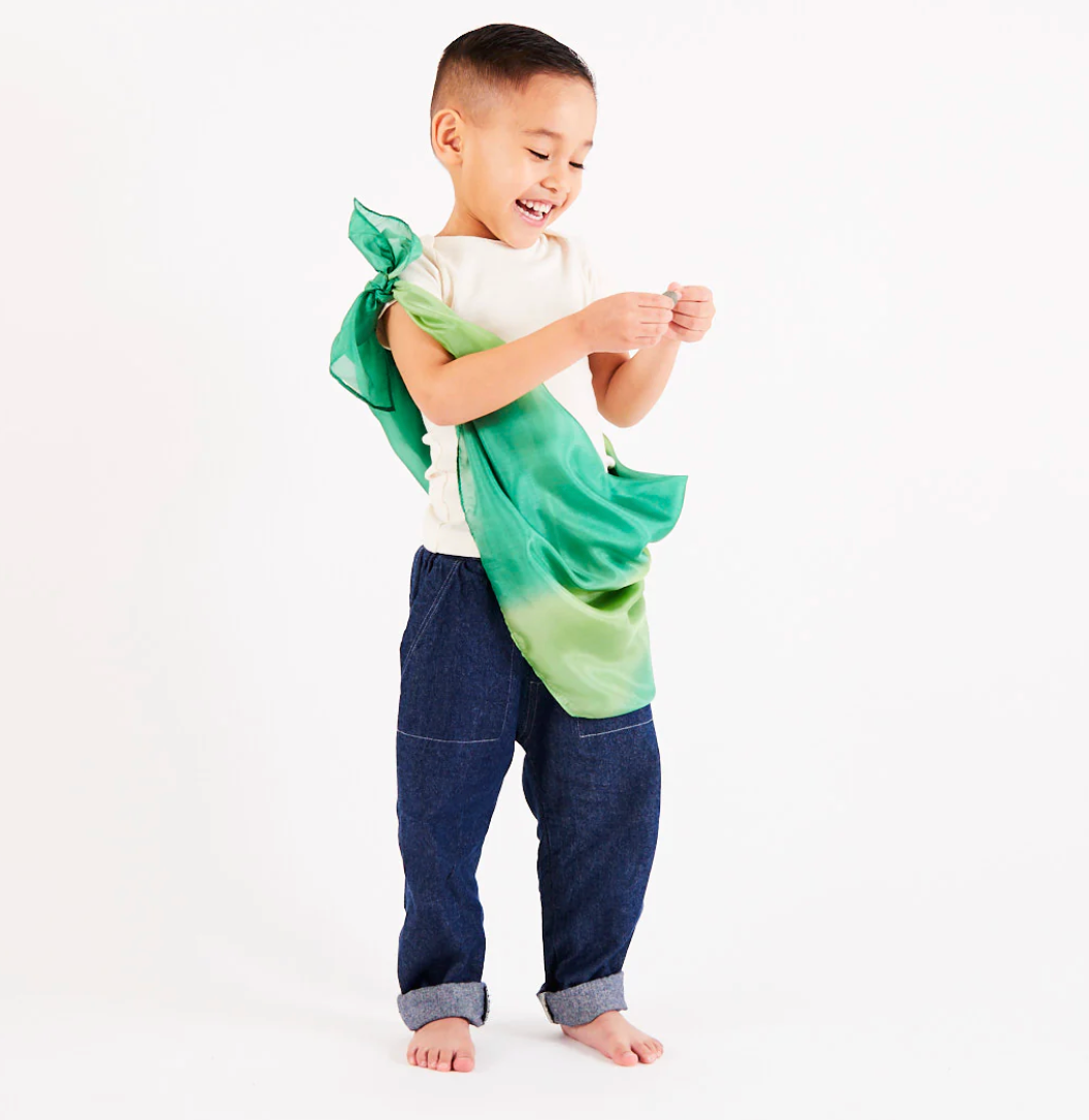 A child wears a playsilk as a sling The Doodle Post